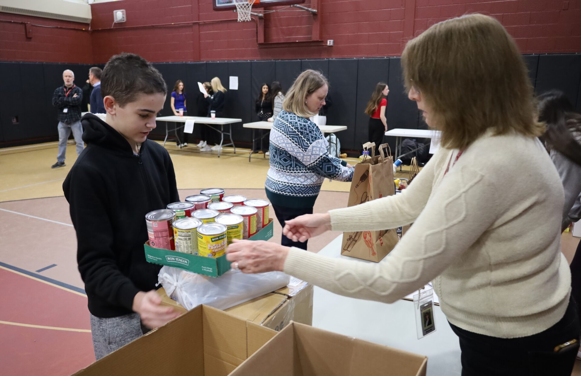 Students bring in non-perishable food items for the annual Project 300 donation drive at McCarthy Middle School in Chelmsford on Thursday, January 15, 2026.