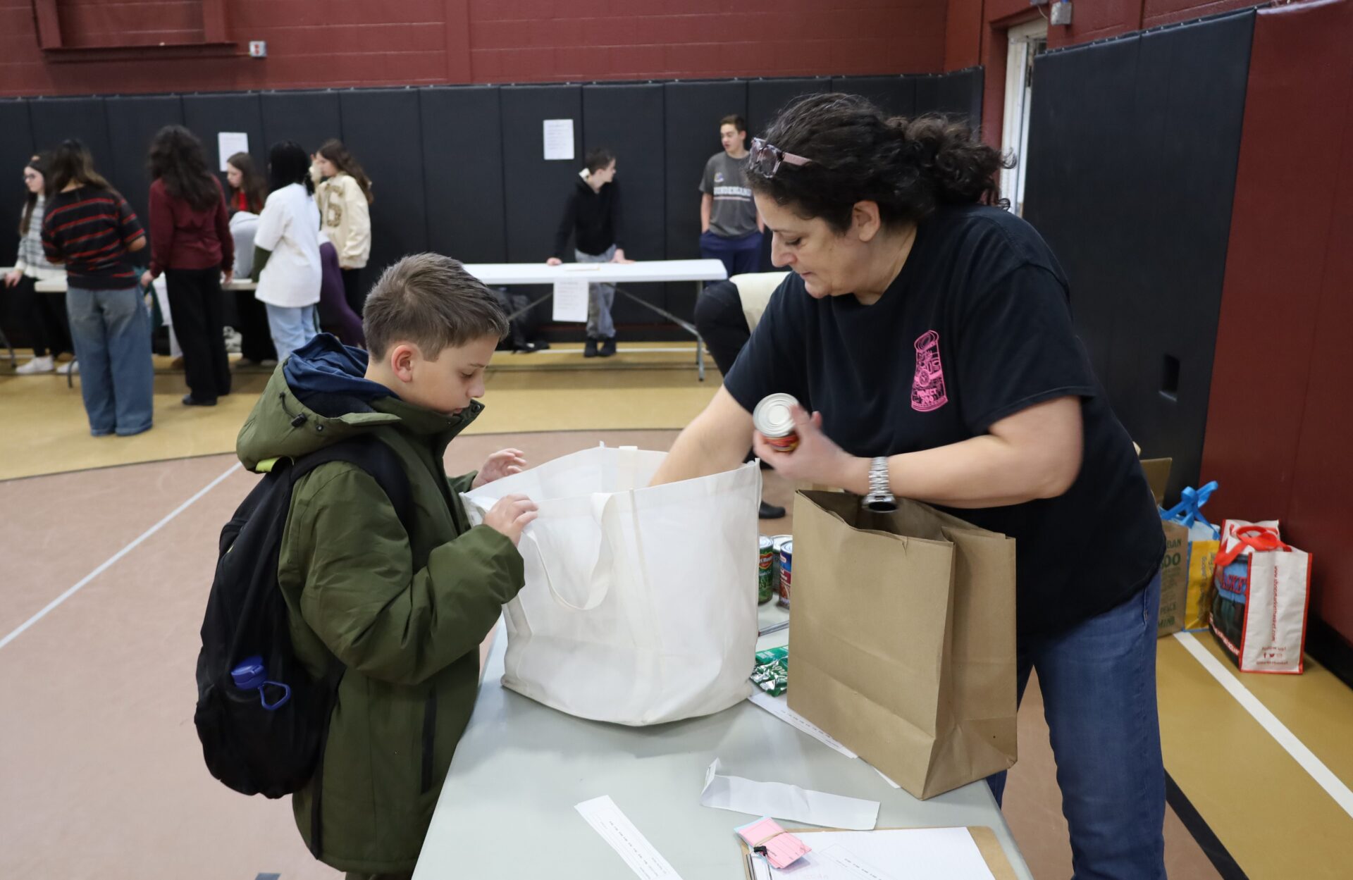 Students bring in non-perishable food items for the annual Project 300 donation drive at McCarthy Middle School in Chelmsford on Thursday, January 15, 2026.